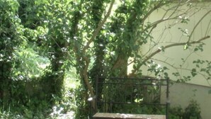 A bench under a tree in a grassy area with dense foliage. - Bille Comfortable Holiday Residence (Luckenwalde)