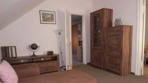 A cozy living room with a brown sofa, a wooden cabinet, and a lamp. - Bille Comfortable Holiday Residence (Luckenwalde)