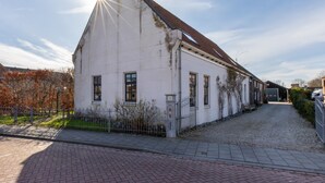 Un bâtiment blanc avec un toit en pente et une enseigne portant le chiffre « 25 ».
