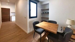 A dining area with a wooden table and chairs, a window, and a lamp. - Apartment in Puerto del Rosario Near Playa Chica (Puerto del Rosario)