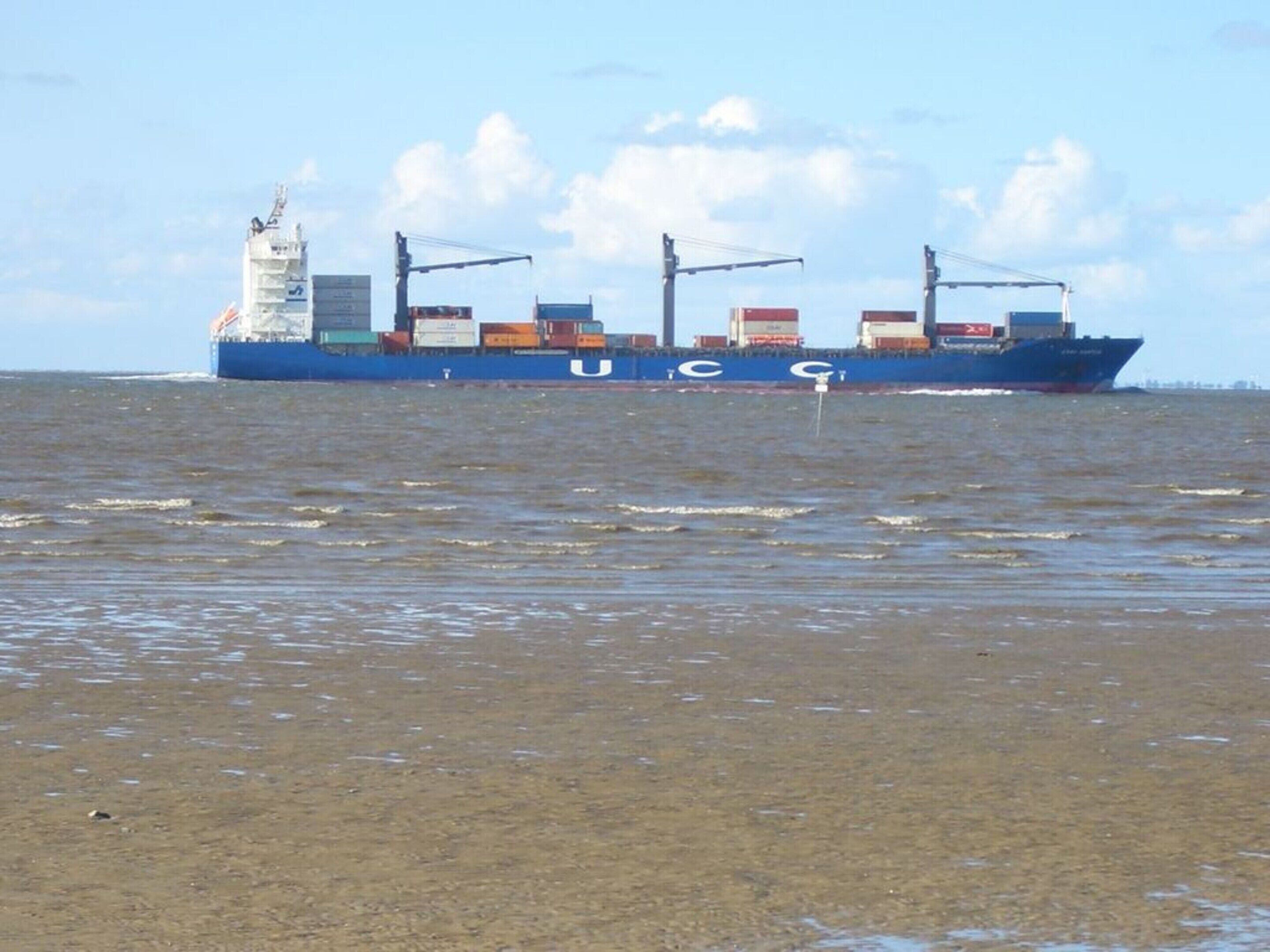 Een groot vrachtschip met meerdere containers op het water.