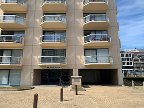 Un edificio de varios pisos con balcones, un letrero que dice "MORGENZON" y una bicicleta estacionada adelante.