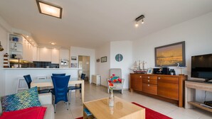 Una sala de estar moderna con un sofá, una mesa de centro y un comedor con sillas y una mesa.