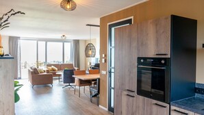 A modern kitchen with wooden cabinets and a built-in oven. - Villa in Leons Near Frisian Lakes (Leons)