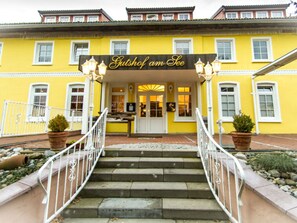 Un bâtiment jaune sur lequel on peut lire l’inscription « Gutshof am See ».