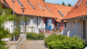 A narrow pathway leading to a row of houses with red-tiled roofs and dormer windows. - 5 Person Holiday Park Home in Gudhjem (Gudhjem)