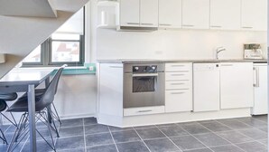 A modern kitchen with white cabinets, a built-in oven, and a coffee maker. - 5 Person Holiday Park Home in Gudhjem (Gudhjem)