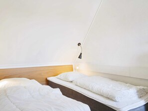 Una habitación sencilla y limpia con dos camas y una lámpara de noche.
