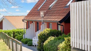 A narrow pathway leading to a row of houses with red roofs and white railings. - 5 Person Holiday Park Home in Gudhjem (Gudhjem)