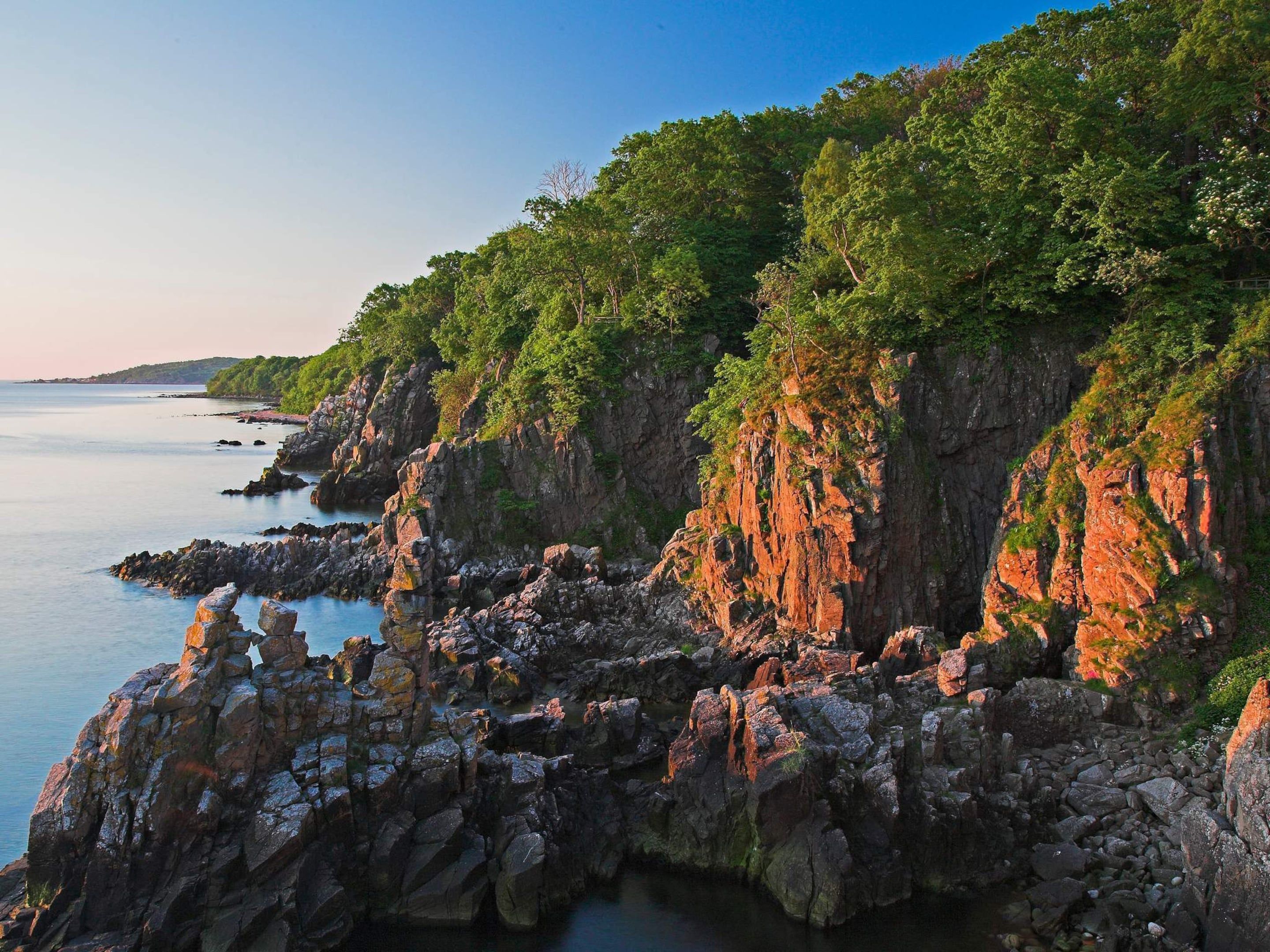 Eine Küstenlandschaft mit felsigen Klippen und ruhigem Meer.