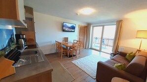 A compact living space with a kitchenette, dining area, and a sofa. - the Veitenhof Comfortable Holiday Residence (Umhausen)