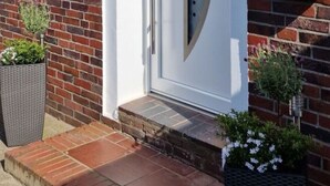 A modern brick house with a white door, a small window, and a white mailbox. - Beach Chair No.1 Comfortable Vacation Home (Wangerland)