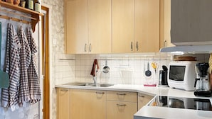 Eine moderne Küche mit Holzausstattung, einem Edelstahl-Spülbecken und einem eingebauten Backofen.
