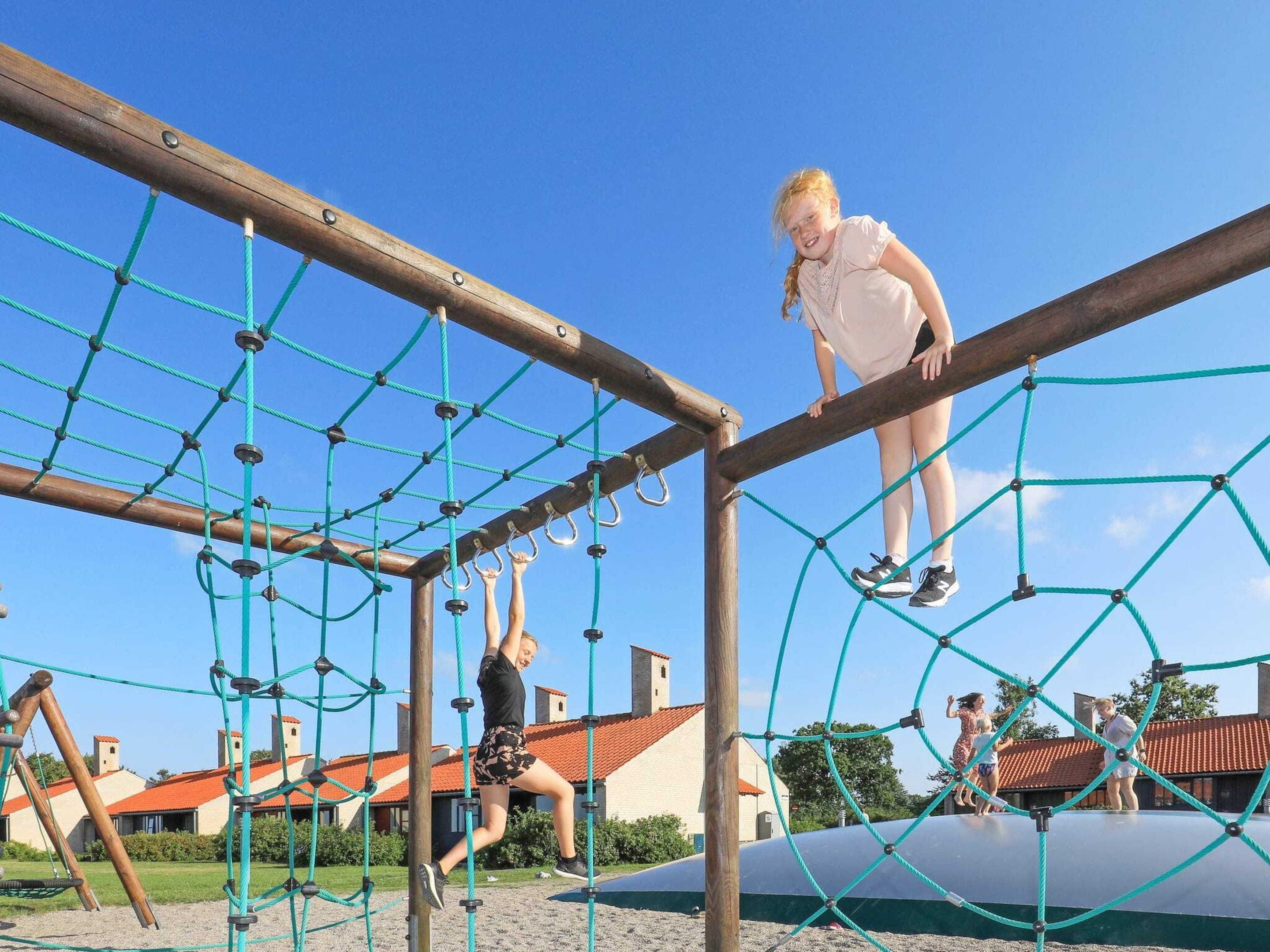 A playground with a net structure and wooden beams.