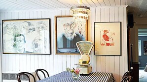 A dining area with a striped tablecloth, framed artwork on the wall, and a vintage cheese grater as a centerpiece. - Holiday Home With art (Leipzig)