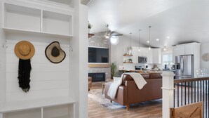Una cocina moderna con gabinetes blancos, un microondas integrado y un refrigerador de acero inoxidable.