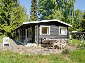 A small cabin with a porch, a covered outdoor seating area, and a garden path. - 6 Person Holiday Home in Rorvig (Rørvig)
