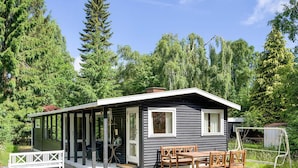 A small cabin with a covered porch, a dining table with chairs, and a bench. - 6 Person Holiday Home in Rorvig (Rørvig)