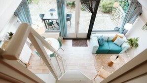 Ein modernes Interieur mit einer Treppe zu einem Essbereich und einer gemütlichen Sitzecke mit Sofa und rundem Tisch.