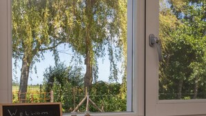 Ein Fenster mit Blick auf Bäume und einem Schild mit der Aufschrift 'Welcome bij Solemar'.