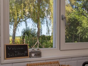 Ein Fenster mit Blick auf Bäume und einem Schild mit der Aufschrift 'Welcome by Solemary'.