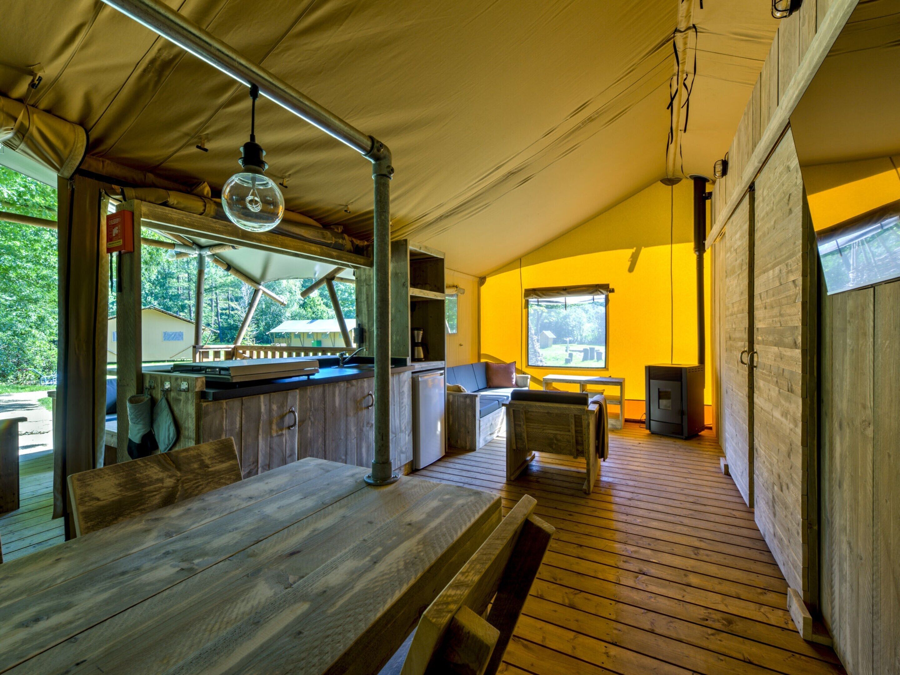 Una cabaña rústica con una mesa de comedor de madera, una zona de bar y un rincón de descanso acogedor.