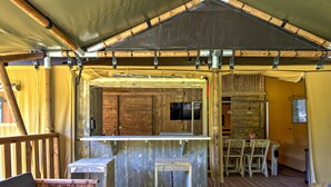 A rustic wooden interior with a bar area, seating, and a television.