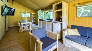A cozy cabin interior with a dining area, a kitchenette, and a seating area with a couch and chairs.