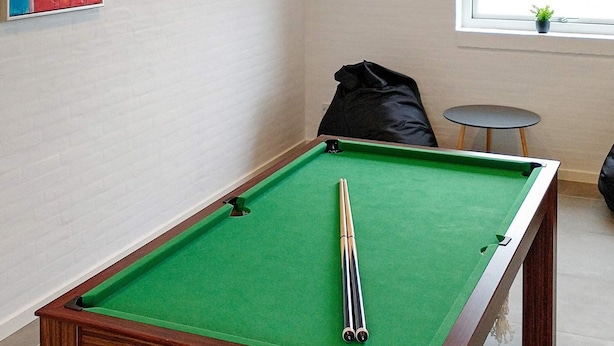A pool table with a green felt surface and a pool cue in the center. - 12 Person Holiday Home in Lemvig (Lemvig)