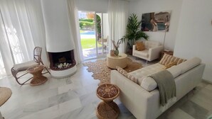A modern living room with a fireplace, a sofa, a chair, and a coffee table.