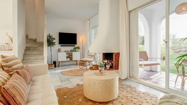 A modern living room with a sofa, a round coffee table, and a fireplace.