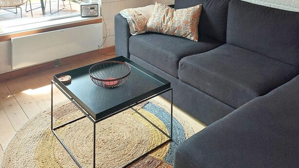 A modern living room with a black coffee table, a grey sofa, and a patterned throw pillow. - 4 Person Holiday Home in Karrebaeksminde (Karrebæksminde)