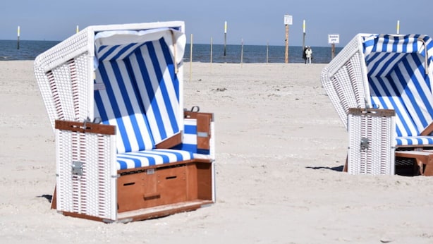 Two beach chairs with blue and white striped cushions on a sandy beach. - Beach Whispers Modern Retreat (Garding)