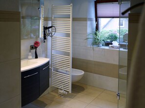 Ein modernes Badezimmer mit Toilette, Waschbecken und Dusche.