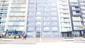 Ein modernes, mehrgeschossiges Gebäude mit zentralem Eingang, großen Fenstern und einer flachen Fassade.