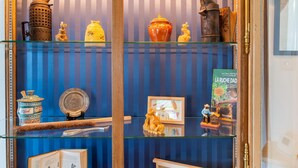 Una exhibición de objetos antiguos de cocina, incluyendo una tetera, un azucarero y un azucarero con tapa.