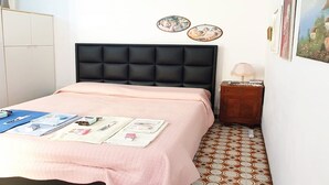A bedroom with a bed, bedside table, and wall decorations. - Apartment in Matera Near Historic Center (Matera)