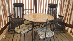 A round table with a mosaic tile design surrounded by four chairs with patterned cushions. - Apartment in Matera Near Historic Center (Matera)