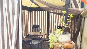 A patio area with a round table and chairs, a potted plant, and a large ceramic vase. - Apartment in Matera Near Historic Center (Matera)