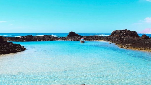 A wooden pier leading into clear turquoise waters with rocky formations on either side. - Apartment in Puerto del Rosario Near Playa Chica (Puerto del Rosario)