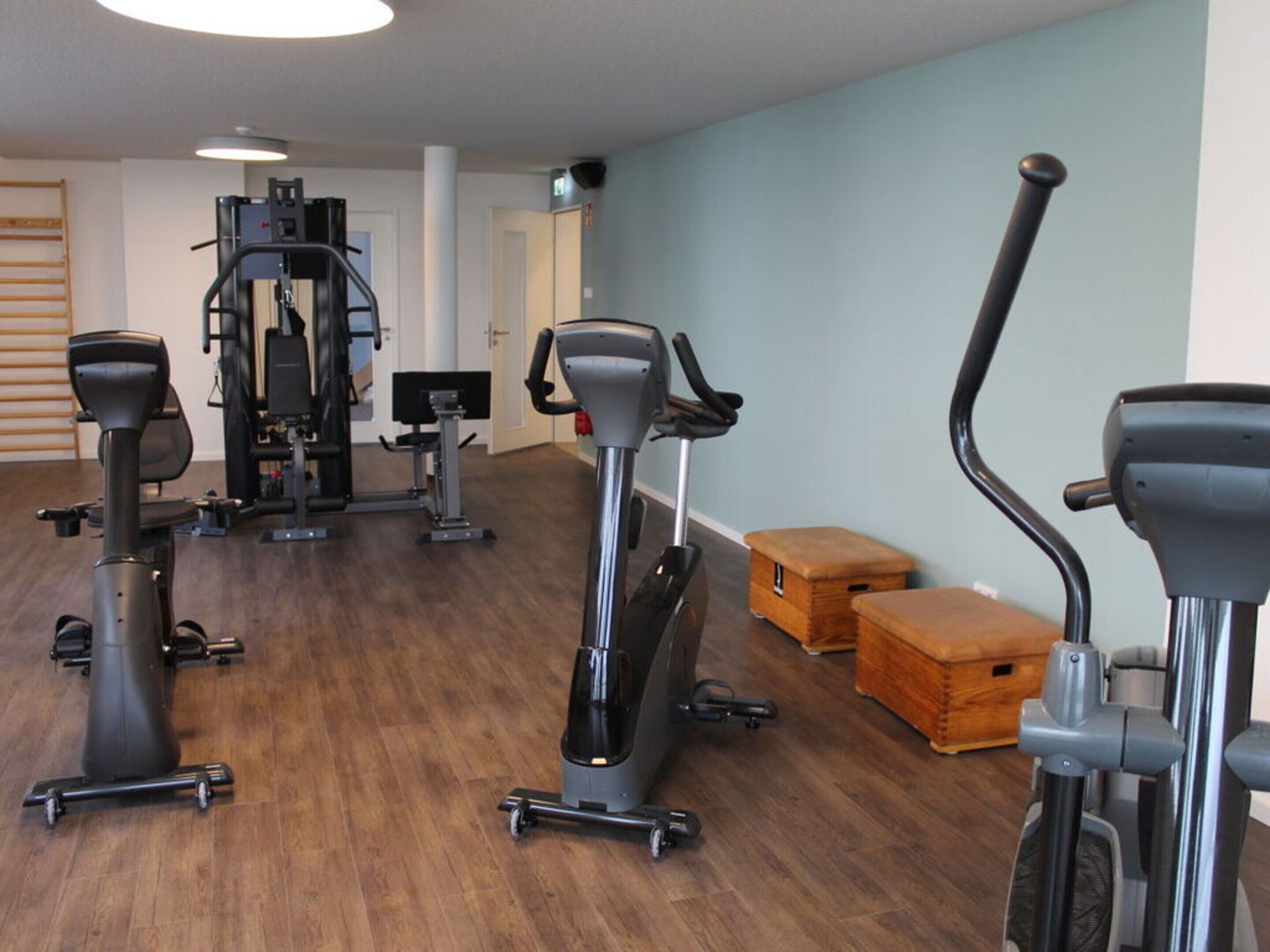 A gym with various exercise equipment including treadmills, stationary bikes, and weight machines.