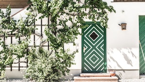 A white building with a green door and a wooden staircase. - Berg-loft Ramsau (Ramsau bei Berchtesgaden)