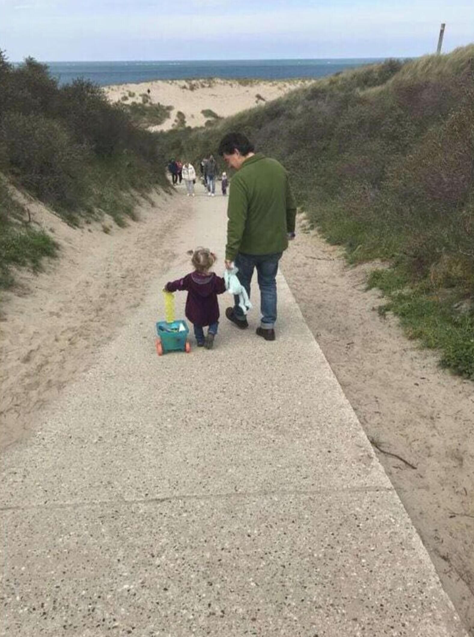 A pathway leading to a beach with people walking.