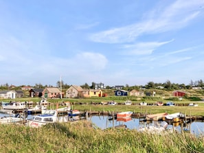 A marina with boats docked, surrounded by houses and greenery. - 5 Person Holiday Home in Ulfborg (Ulfborg)