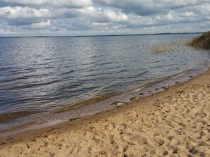 A sandy beach with gentle waves and a cloudy sky. - 5 Person Holiday Home in Ulfborg (Ulfborg)
