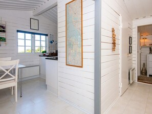 A kitchen with white wooden walls, a map, and a window with blue shutters. - 5 Person Holiday Home in Ulfborg (Ulfborg)