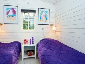 A room with two beds, a small table, and two wall-mounted lamps. - 5 Person Holiday Home in Ulfborg (Ulfborg)