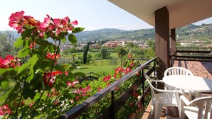 A balcony with a view of a green landscape and buildings in the distance. - Comfortable Apartment in Garda With Swimming Pool (Garda)