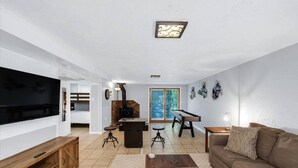 Una sala de estar con televisor, sofá, mesa de centro y chimenea.