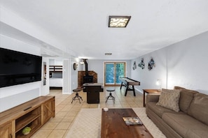 Una sala de estar con televisor, sofá, mesa de centro y chimenea.